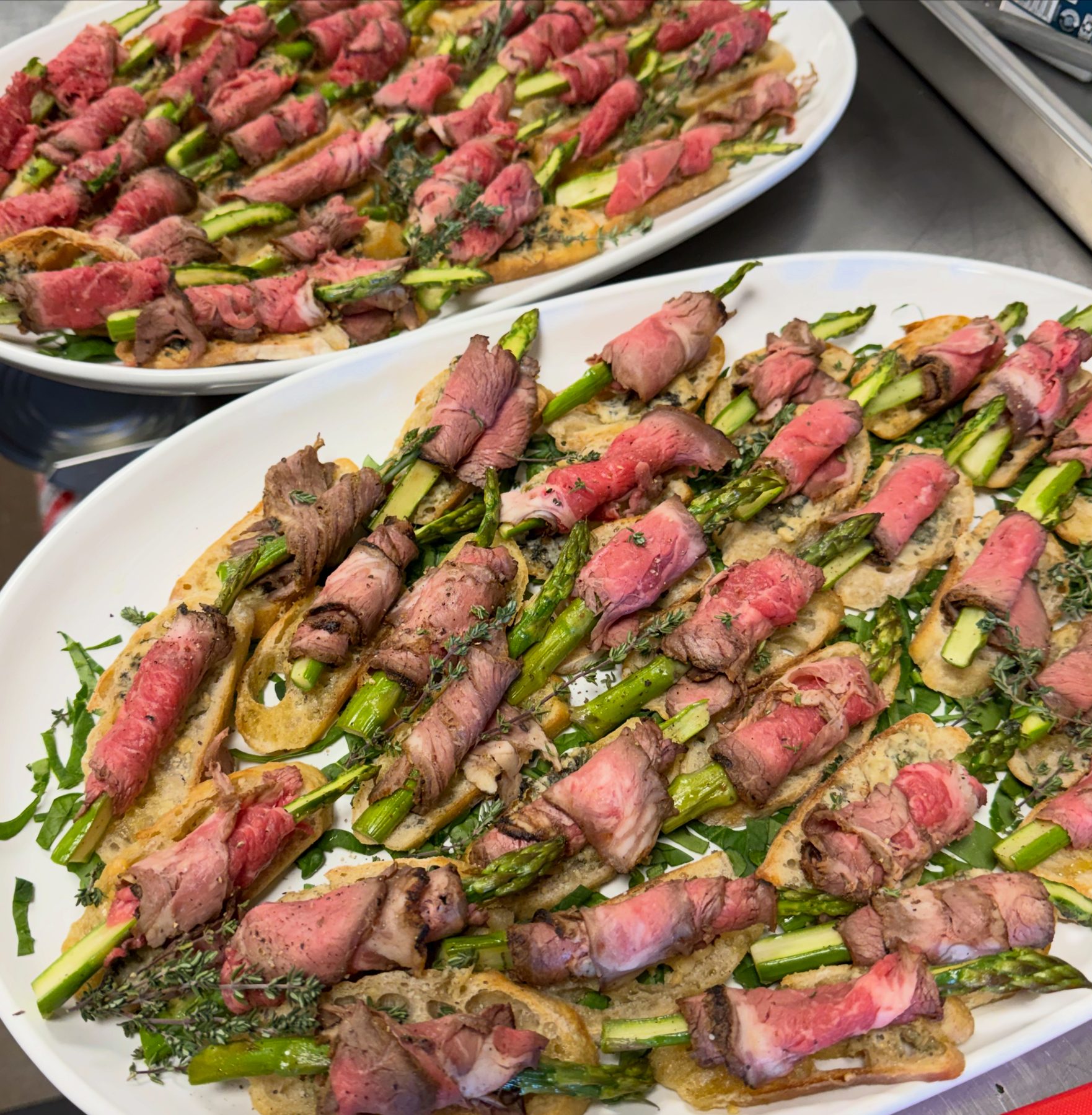 Platters of seared beef and asparagus crostini with thyme