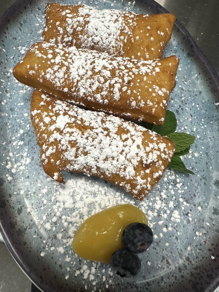 Powdered sugar beignets with lemon curd and blueberries