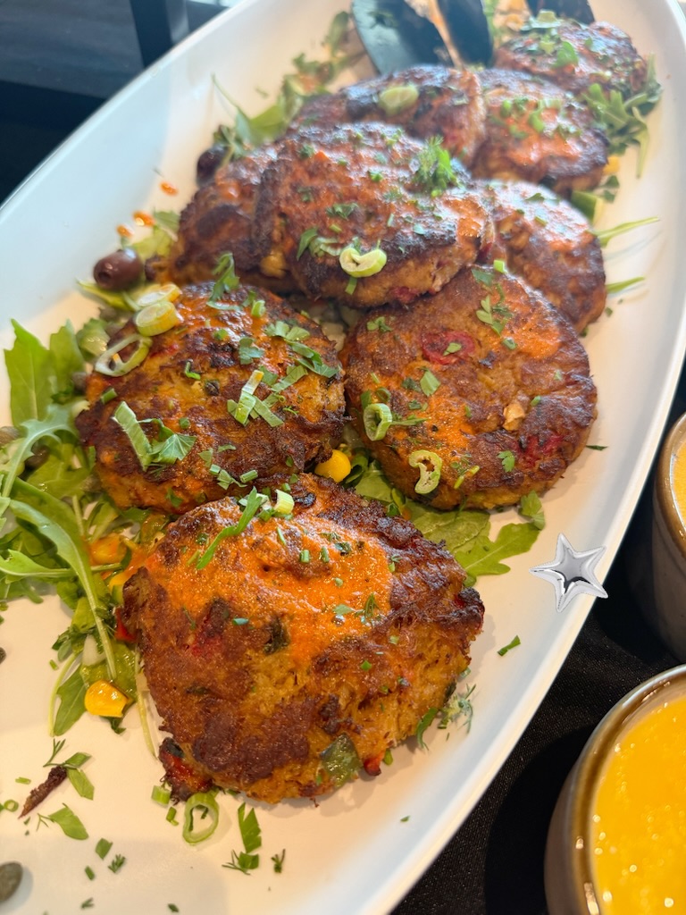 Crab cakes over arugula with two dipping sauces