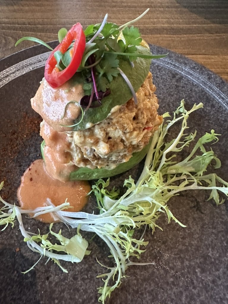 Stacked crab and avocado tower with chili, microgreens and remoulade
