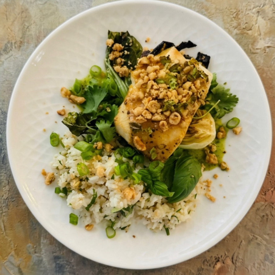 Seared fish over coconut herb rice with bok choy and peanut crumble