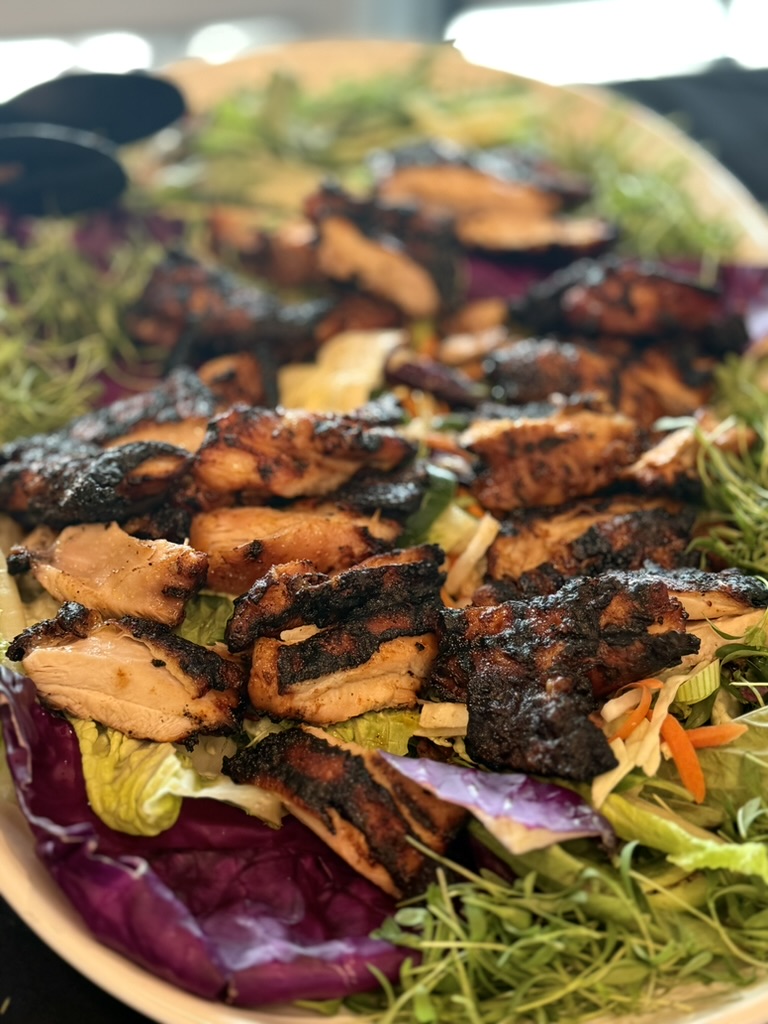 Charred jerk chicken platter over slaw and greens