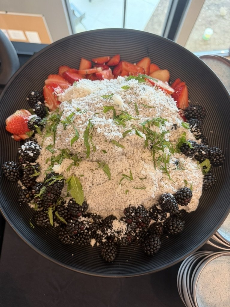 Large bowl of overnight oats with coconut, strawberries, blackberries and mint