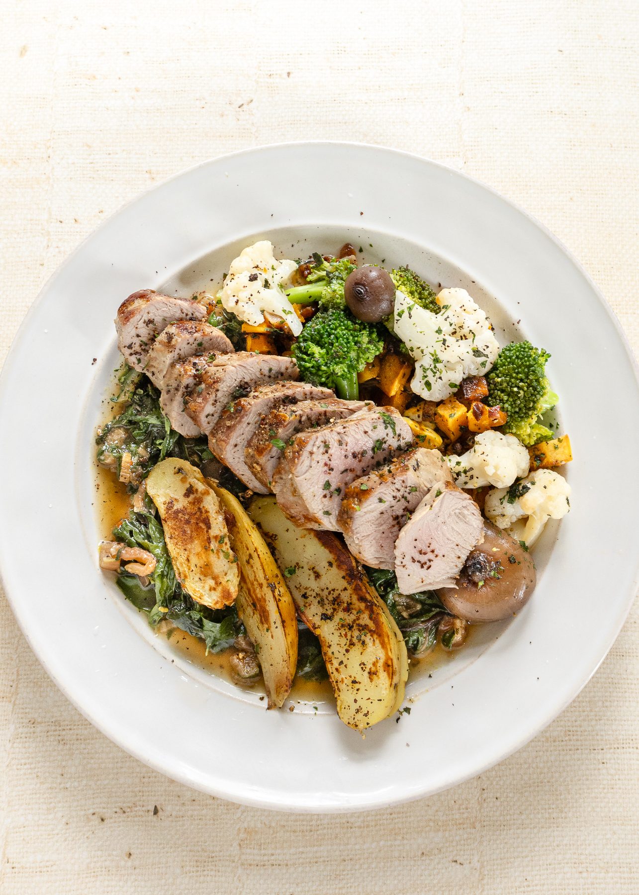 Sliced pork tenderloin with fingerling potatoes, broccoli and cauliflower