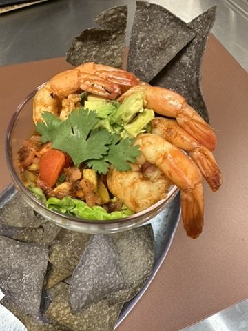 Shrimp ceviche cup with avocado and cilantro, blue corn chips